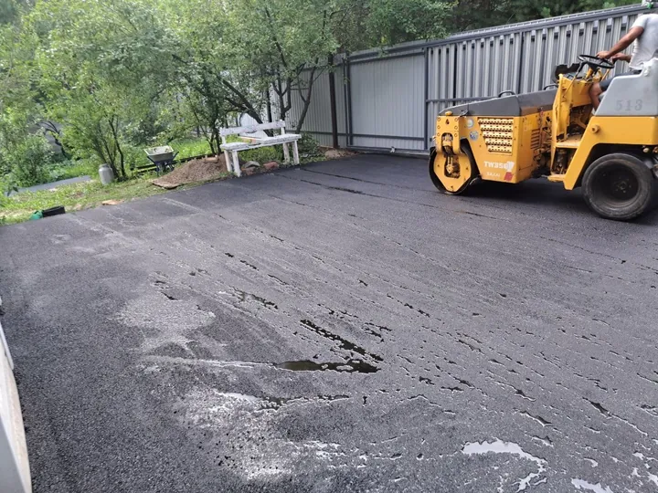 Двор частного дома с катком после укладки асфальта